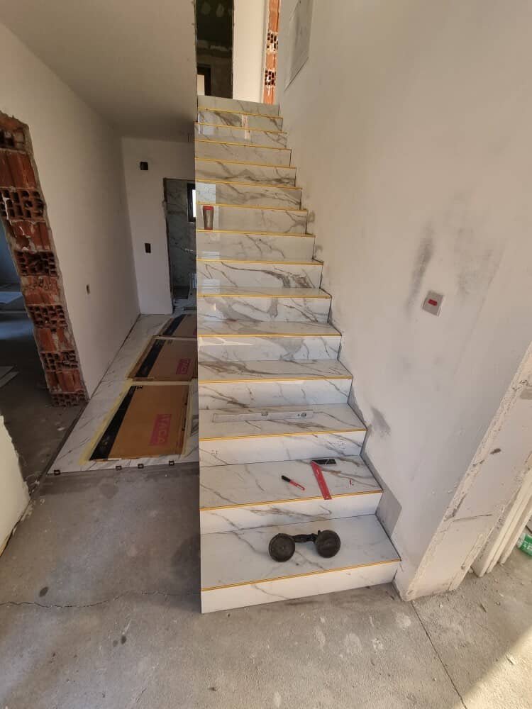 Stepenište obloženo velikim keramičkim pločicama sa zlatnim lajsnama